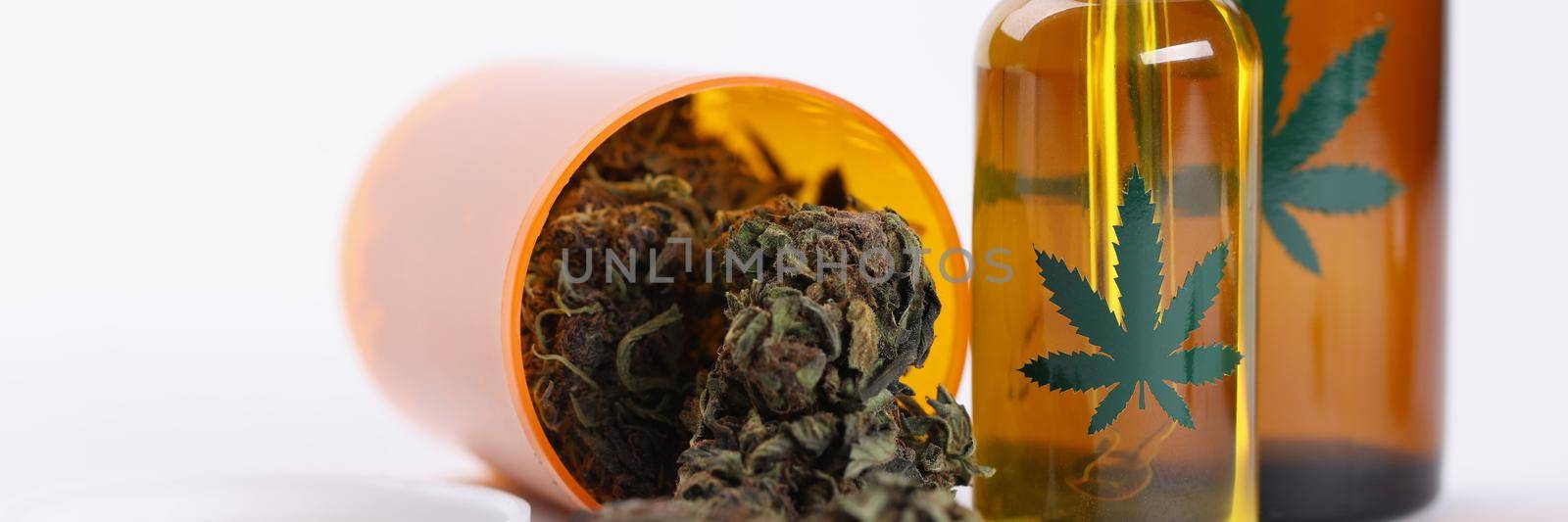 Close-up of dry marijuana buds extract oil and spray in plastic bottles. Medication for home treatment in jars. Alternative medicine, health, hemp concept