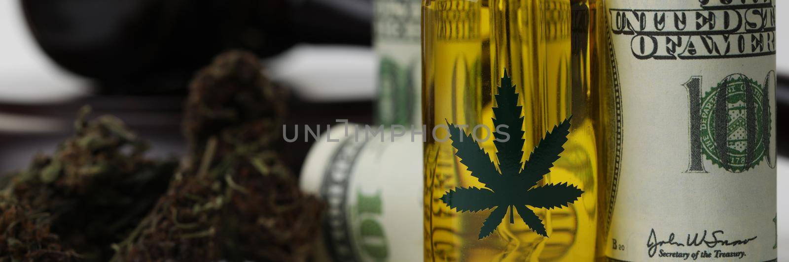 Close-up of cannabis extract oil banknotes and gavel as legalization of marijuana. Legal use of hemp in medicine, smoke for health. Cbd, herb, weed concept