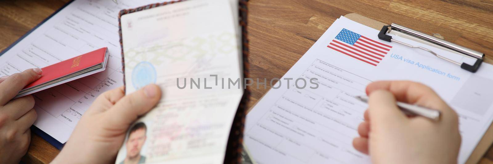 Close-up of people filling visa application forms with personal passports at embassy. Standard process to access country. Immigration, permission concept