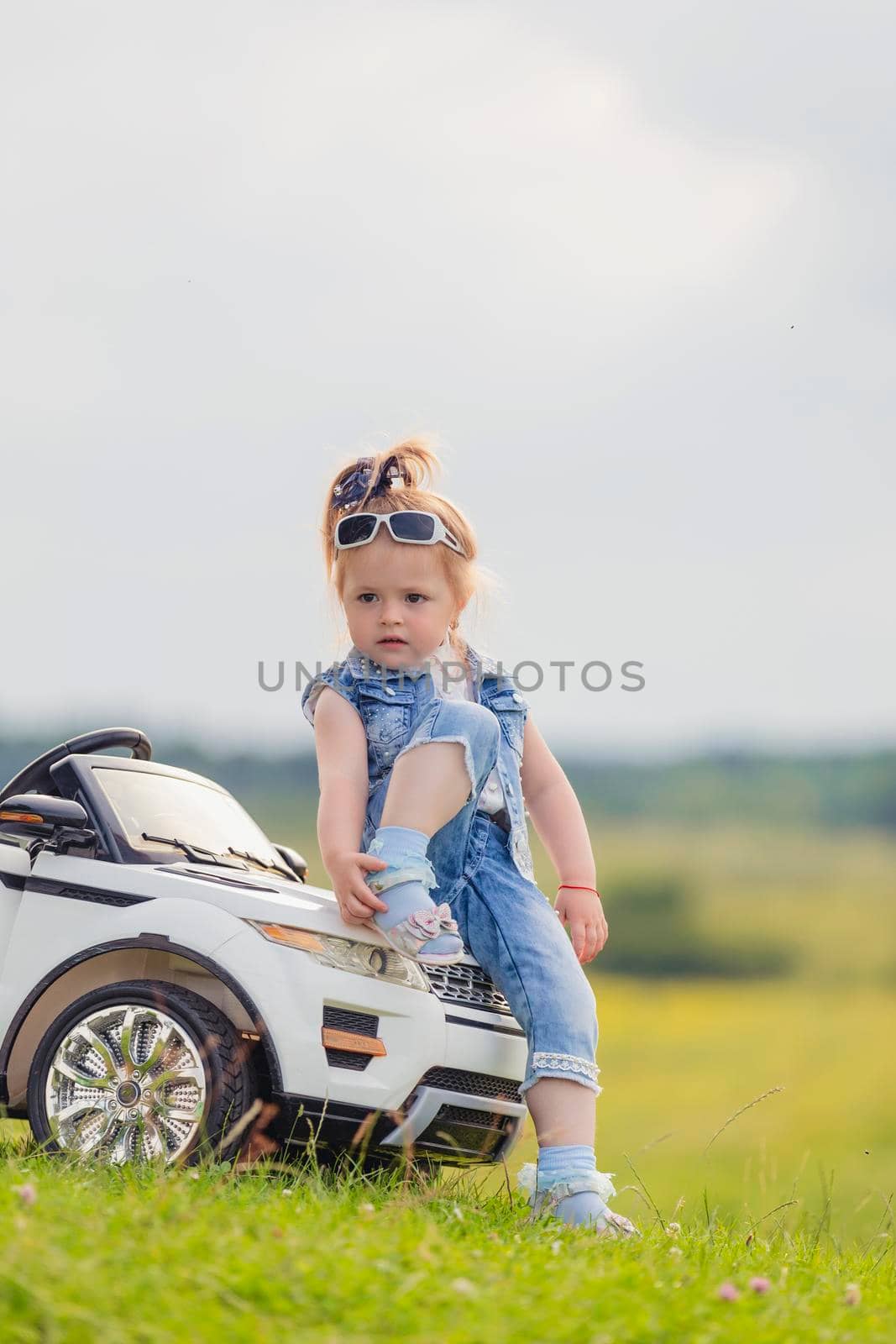 little girl standing near her baby car