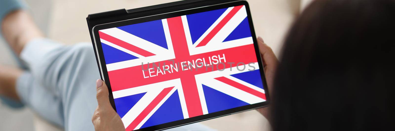 Close-up of woman learn english from home on sofa use tablet device. Learn foreign language remotely from any place. Education, info, online study concept