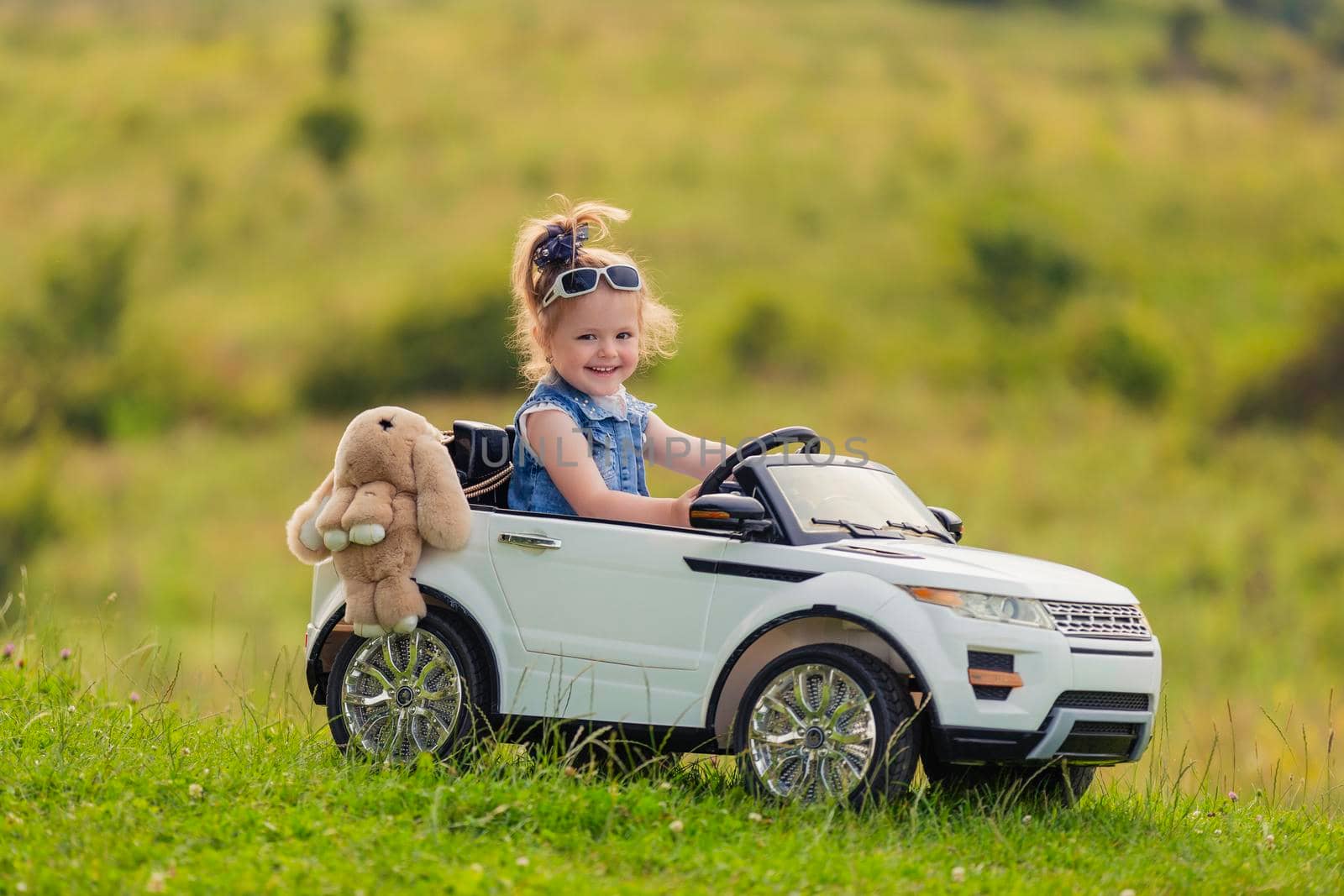 little girl rides in a children's car by zokov