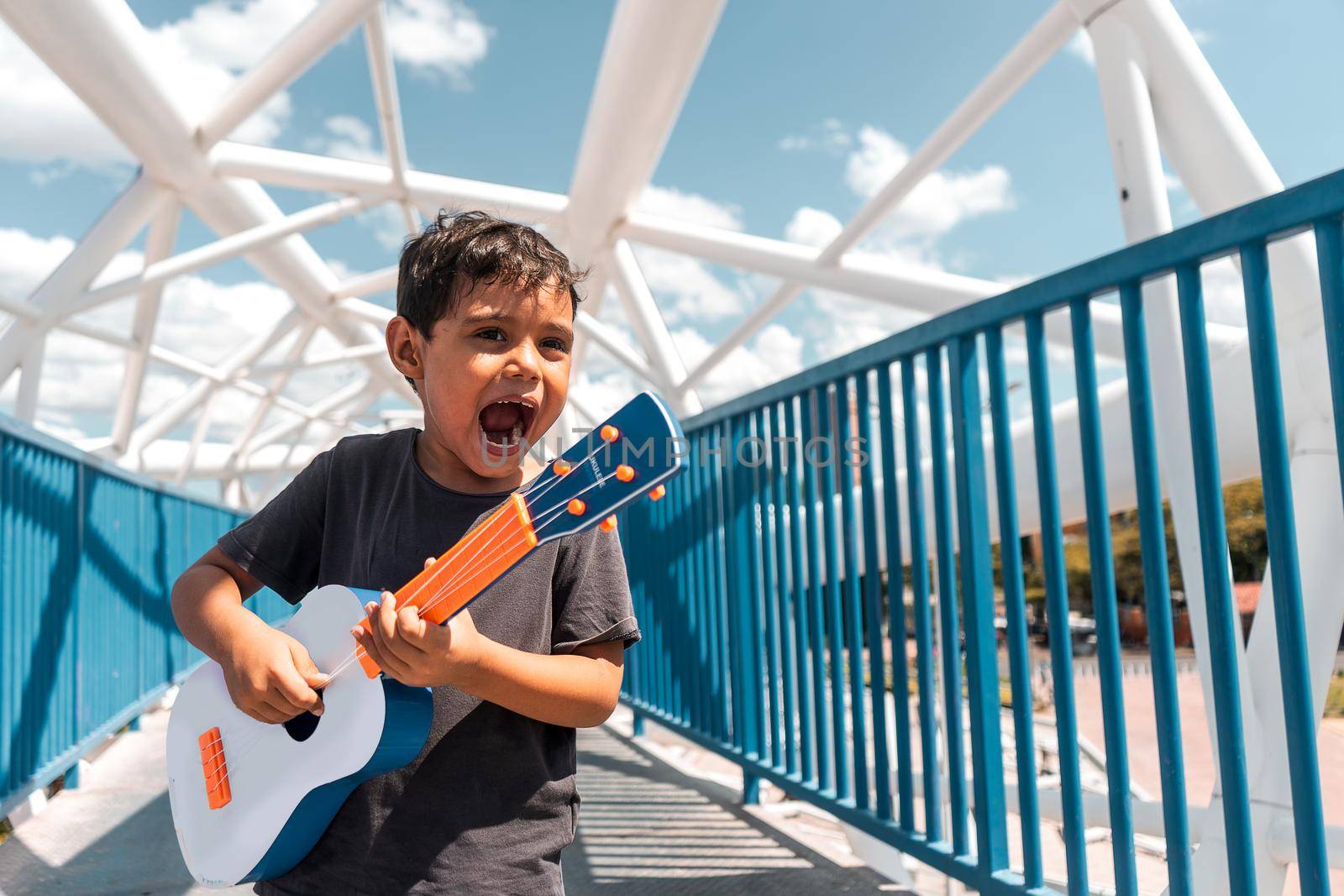 Nicaraguan boy on a bridge playing the ukulele in Managua Nicaragua