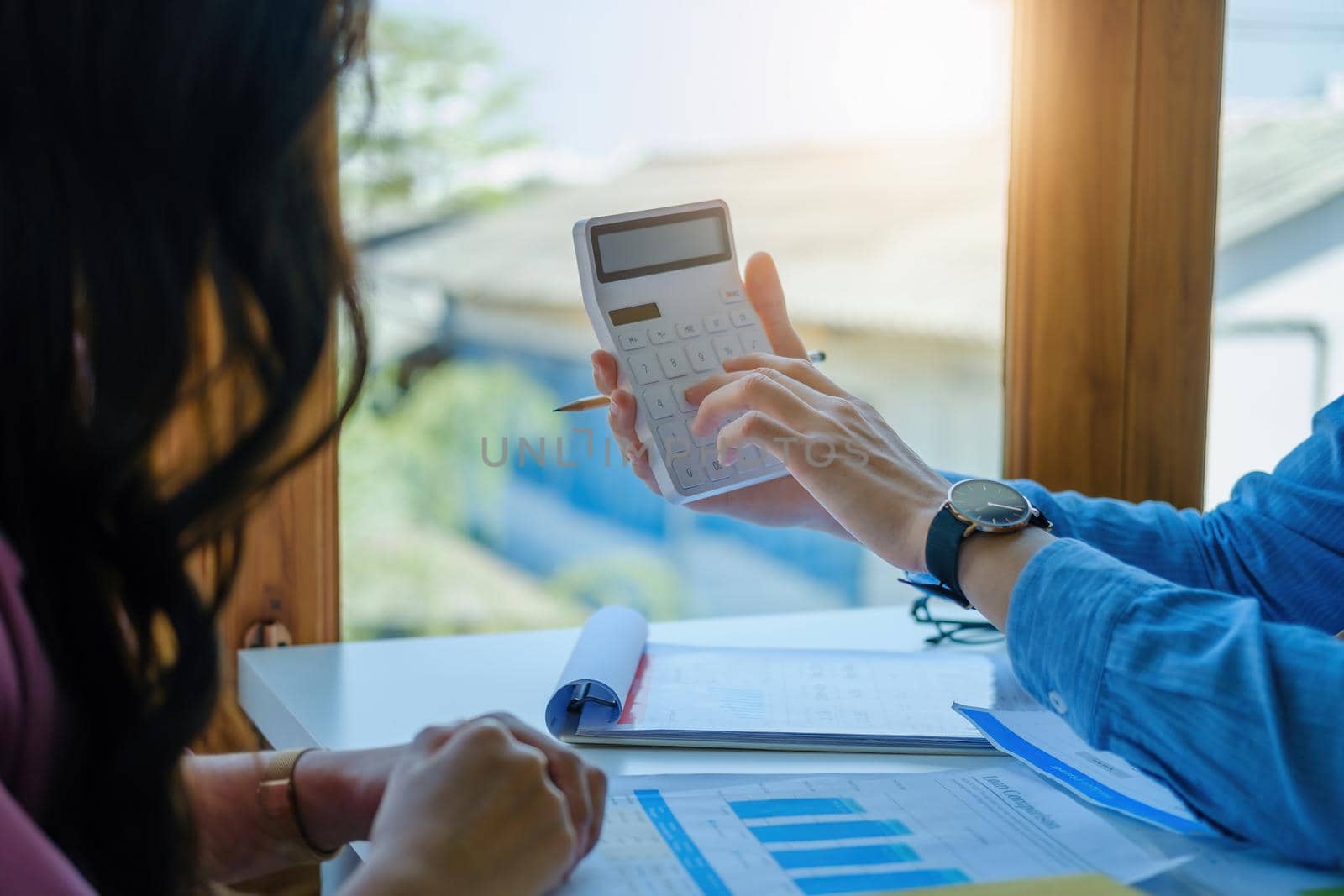 financial, Planning, Marketing and Accounting, Asian young Economist using calculator to calculate investment documents with partners on profit taking to compete with other companies.