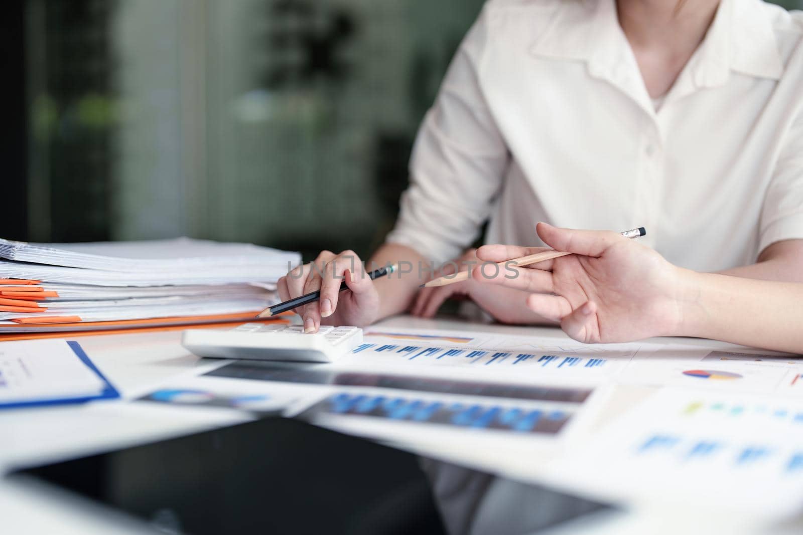 financial, Planning, Marketing and Accounting, Asian young Economist using calculator to calculate investment documents with partners on profit taking to compete with other companies.