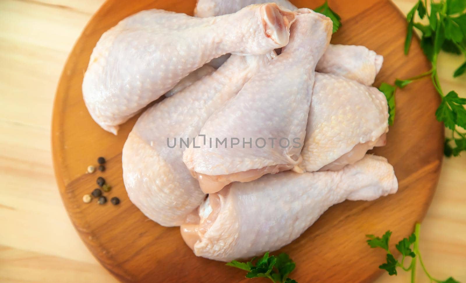 Raw meat chicken drumsticks on a board. Selective focus. Nature.