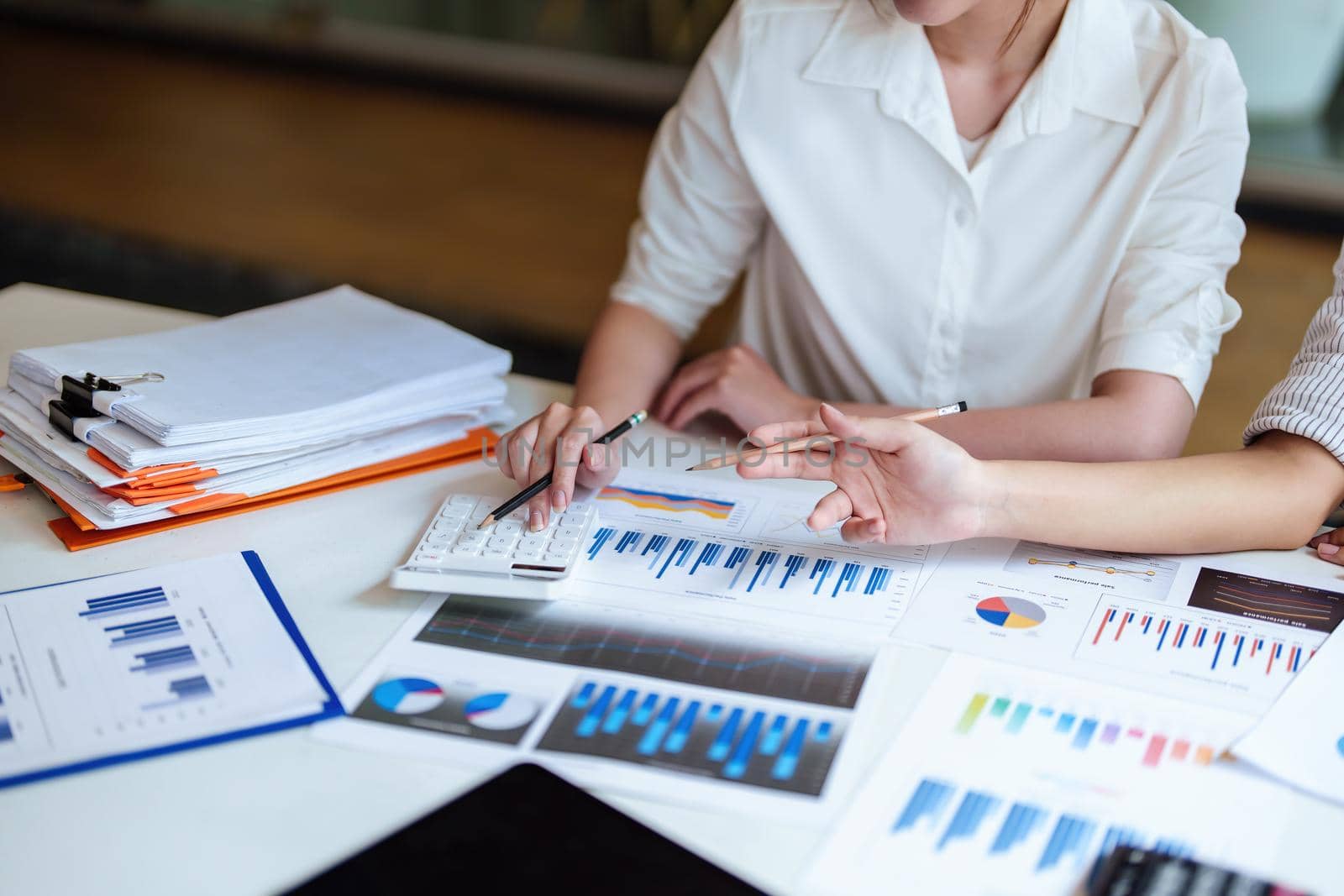 financial, Planning, Marketing and Accounting, Asian young Economist using calculator to calculate investment documents with partners on profit taking to compete with other companies.