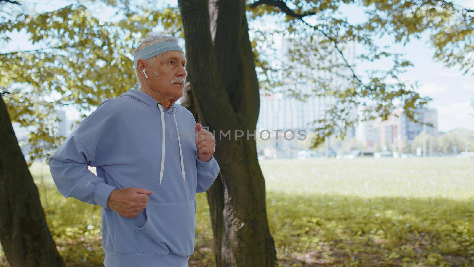 Athletic fitness senior elderly sport runner man training. Workout cardio outside in city park at morning. Happy old grandfather enjoying healthy lifestyle. Active retired mature people motivation