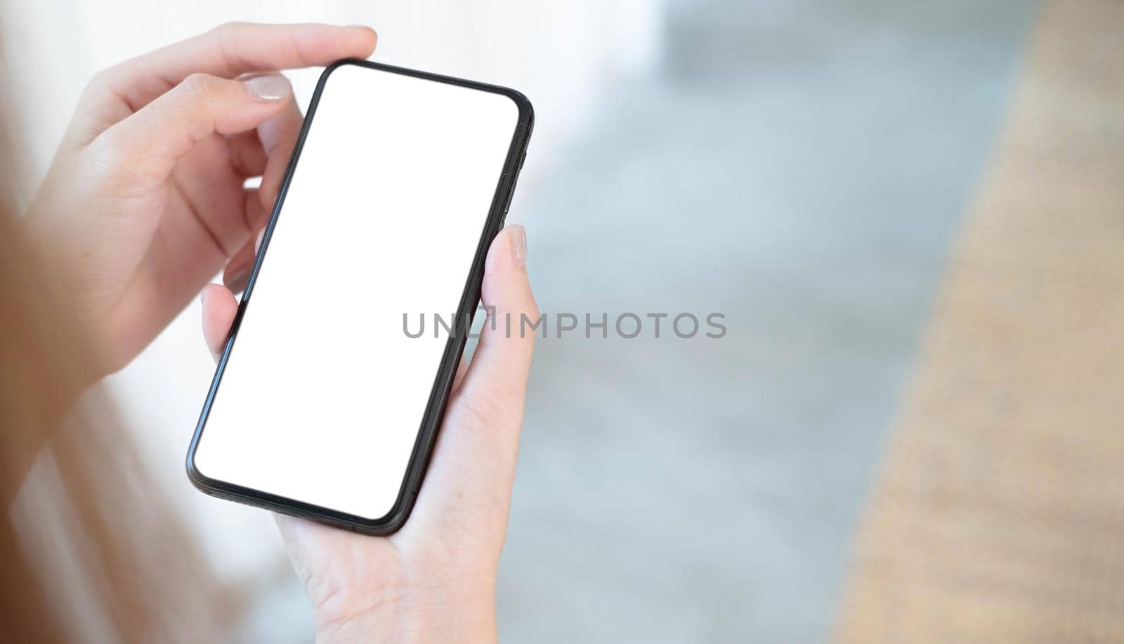 Closeup woman holding smart phone with blurred background. For Graphic display montage. by wichayada
