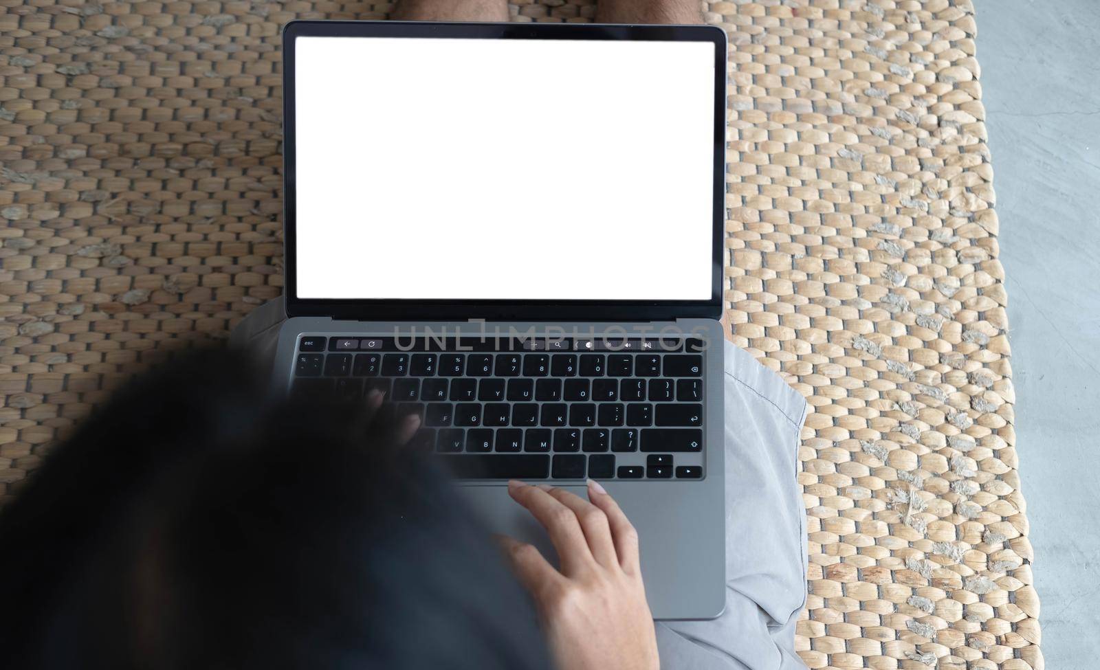 Woman using laptop with blank mock up white empty screen typing on computer at home, mockup copyspace display for ad, job search, study online shopping, website page, e-banking, over shoulder view by wichayada