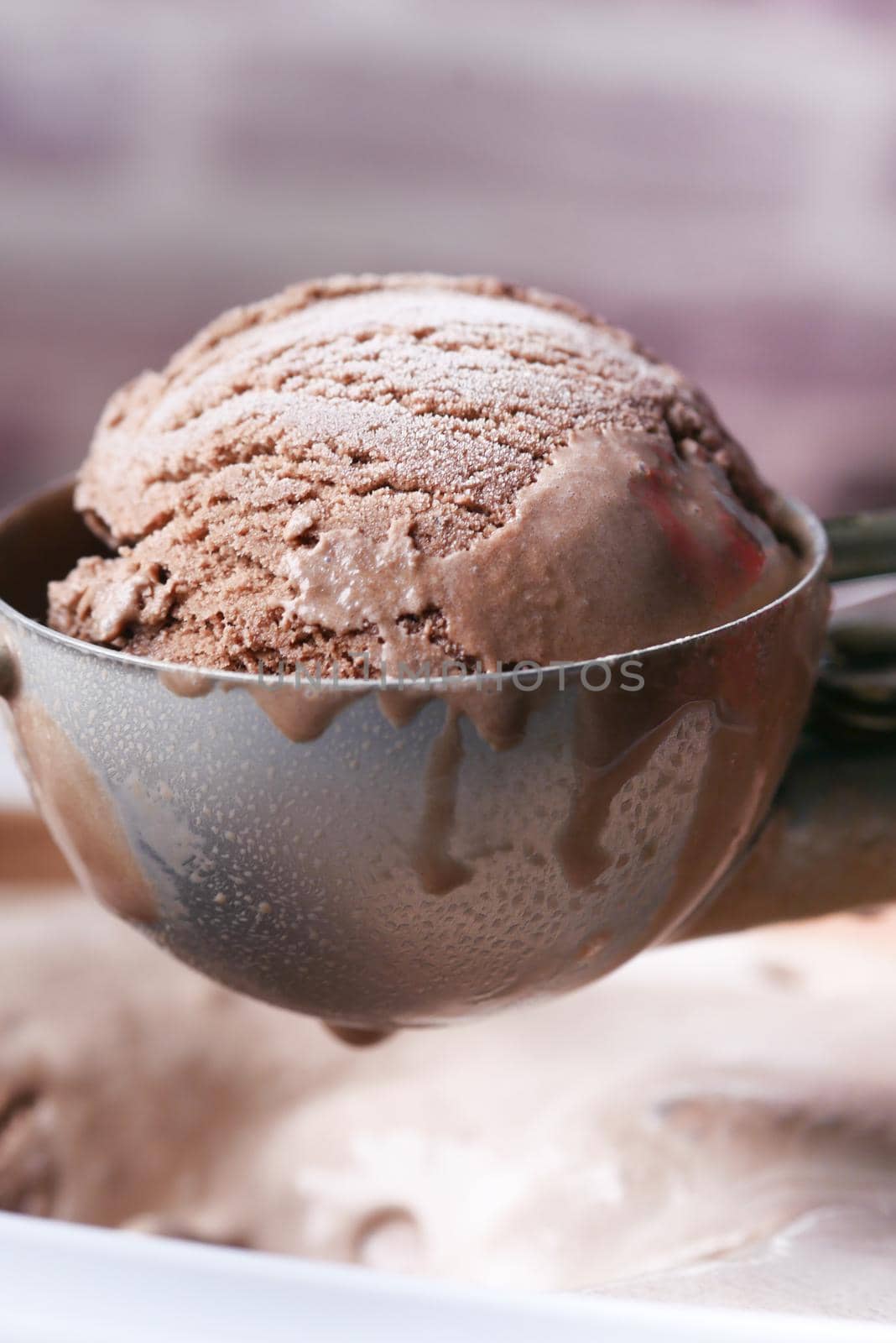 hand picking ice cream with a spoon from a bowl .