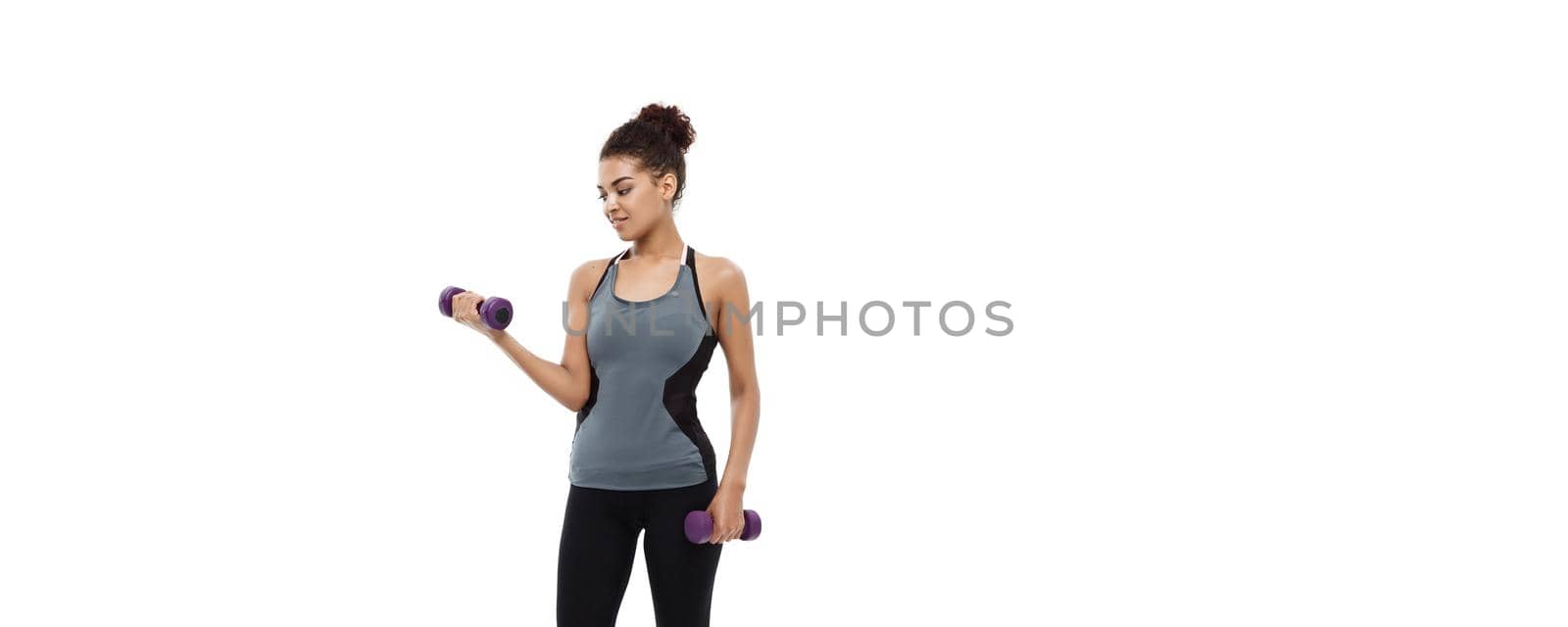 Healthy and Fitness concept - Full-length of portrait Beautiful American African lady in grey fitness clothes workout with dumbbell. Isolated on white background. by Benzoix