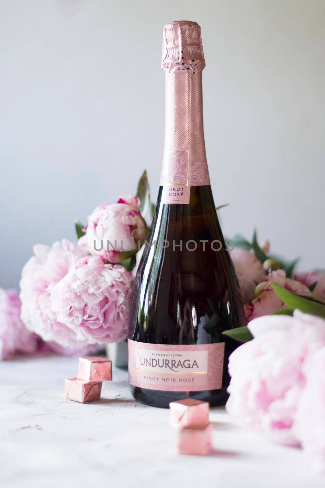 As, Belgium 8 June 2020, Undurraga pink dry champagne for birthday, mother's day gift, still life with pink peonies and chocolates in early spring. High quality photo