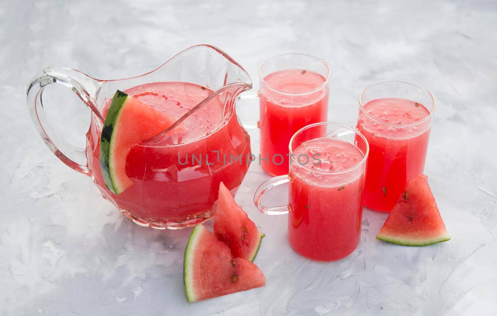 fresh red watermelon drink on hot summer day on light gray cement background. High quality photo