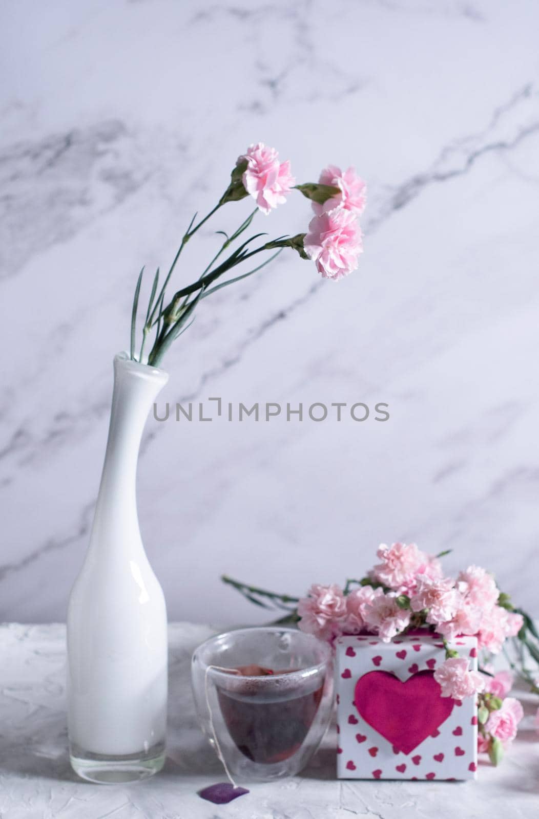 pink carnations in a white vase and coffee cups in a heart-shaped pink box, by KaterinaDalemans