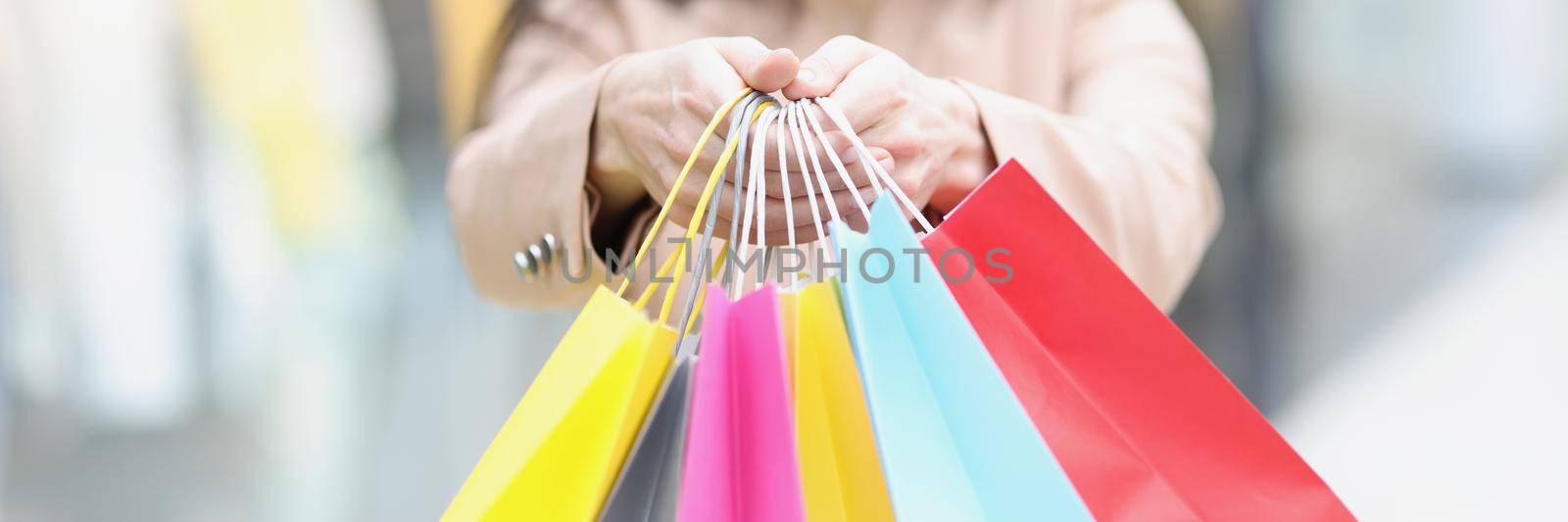 Lady wear face mask and hold bunch of packages after whole day shopping by kuprevich