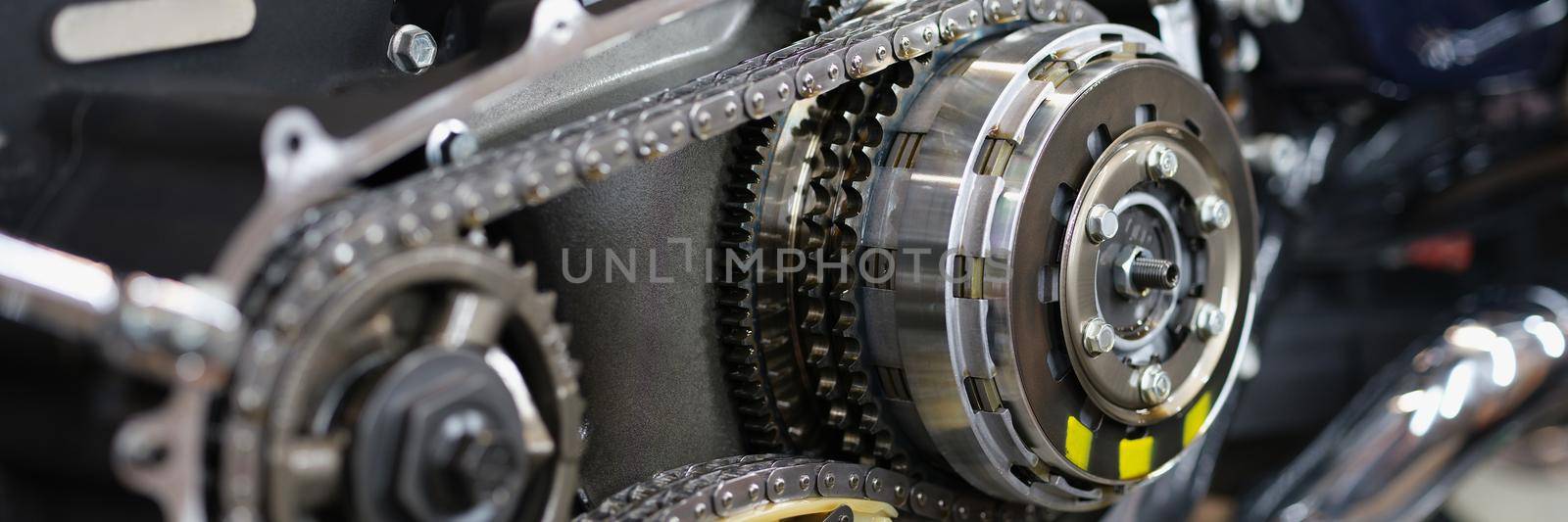 Close-up of shiny detail of cool motorcycle rear chain with exhaust pipes. Brand new model of motorbike. Transportation, vehicle, racing driver concept