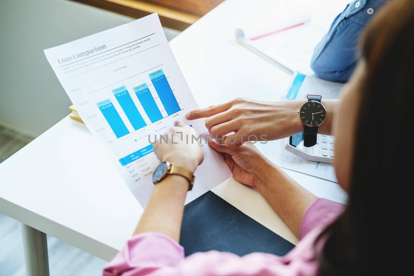 Negotiation, Analysis, Discussion, Portrait of an Asian young economist and marketer pointing to a financial data sheet to plan investments to prevent risks and losses for the company. by Manastrong