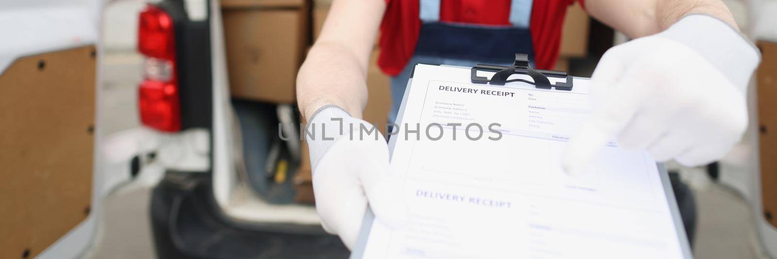 Portrait of man in special uniform and face mask give delivery receipt paper to owner. Worker ask to fill information form. Delivery, high quality concept