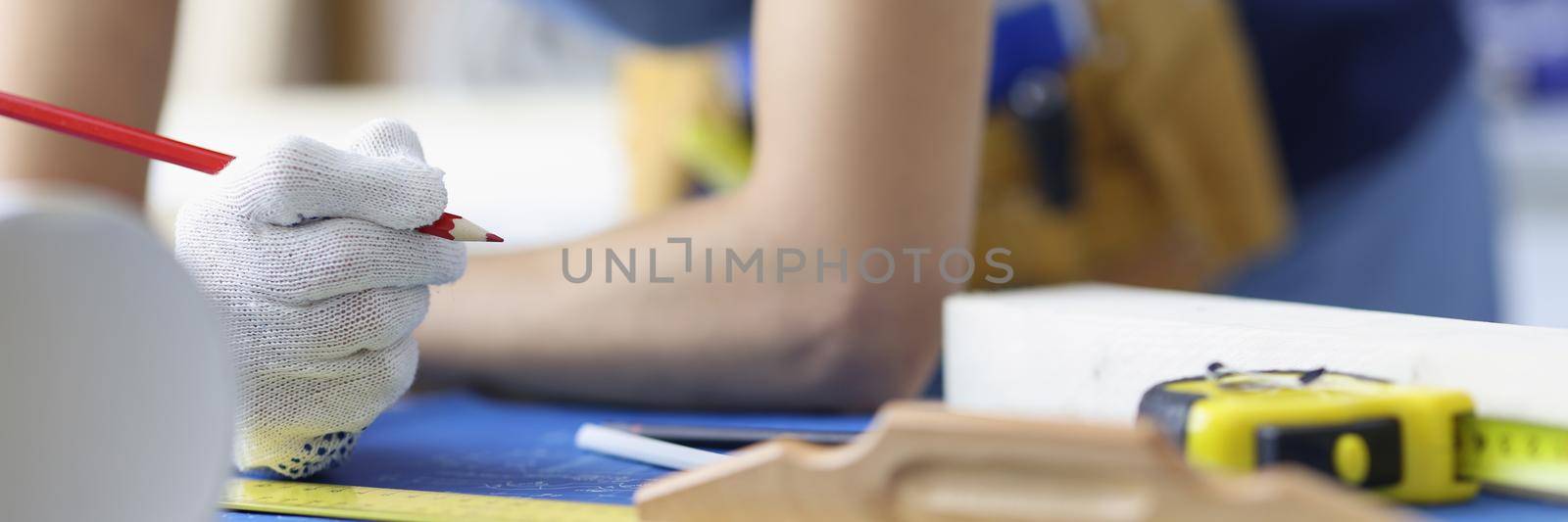 Close-up of woman worker making corrections in construction planning with pencil. Qualified forewoman and blueprint on workplace. Renovation, build concept