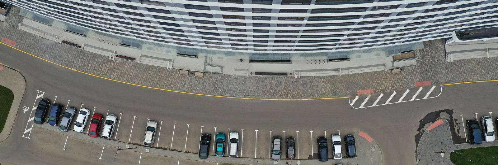 Top view of luxury business centre building with private parking full of cars. Exterior with restrained layout. Architecture, design, construction concept