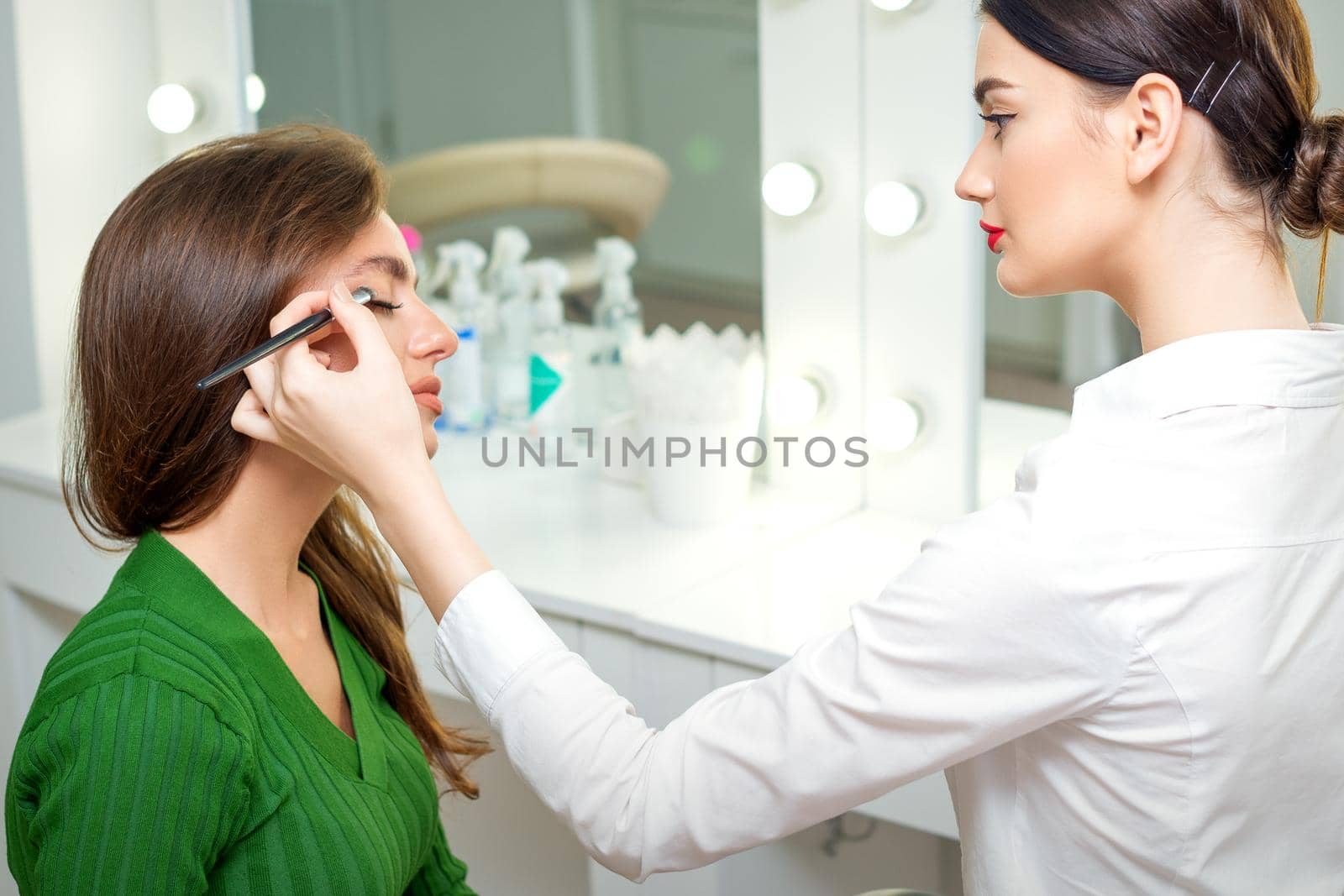 Makeup artist applies eyeshadow. by okskukuruza