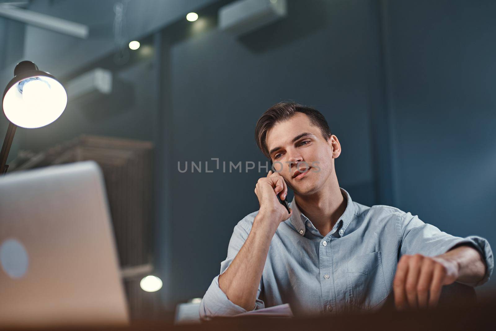 young businessman discussing business issues on a smartphone. by SmartPhotoLab