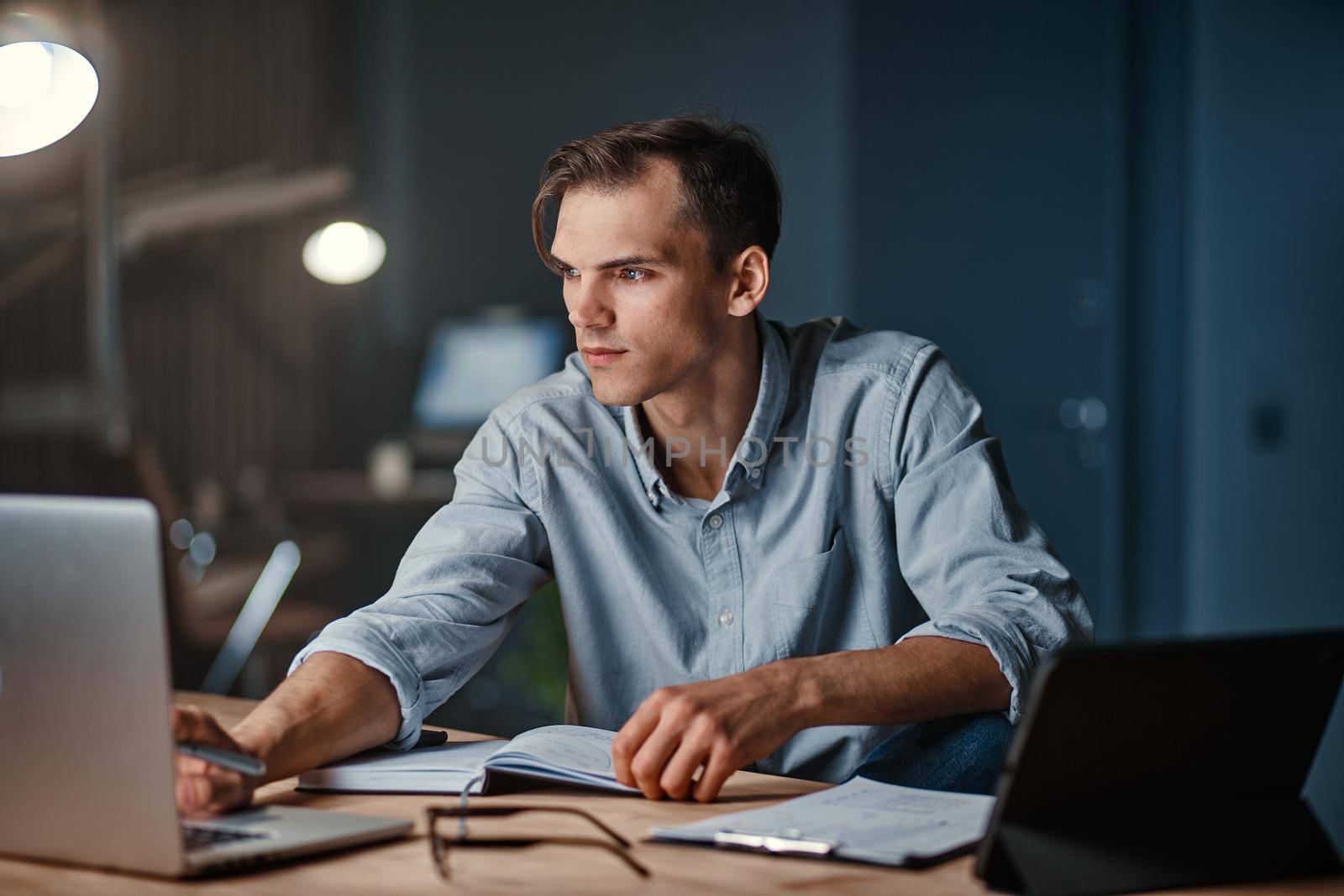 smiling businessman working on a new project at night . by SmartPhotoLab