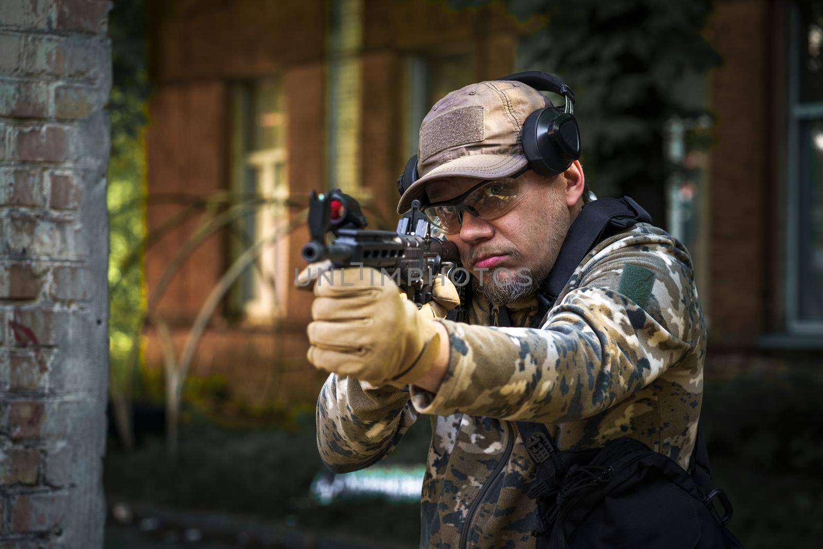 Combat training soldier of special forces. Man in military ammunition stand in guard. Military man hide in position with weapon in hands. Ranger during the military operation.