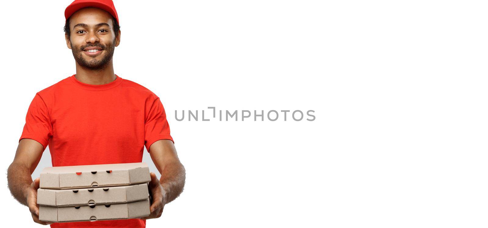 Delivery Concept - Portrait of Handsome African American Pizza delivery man. Isolated on Grey studio Background. Copy Space. by Benzoix