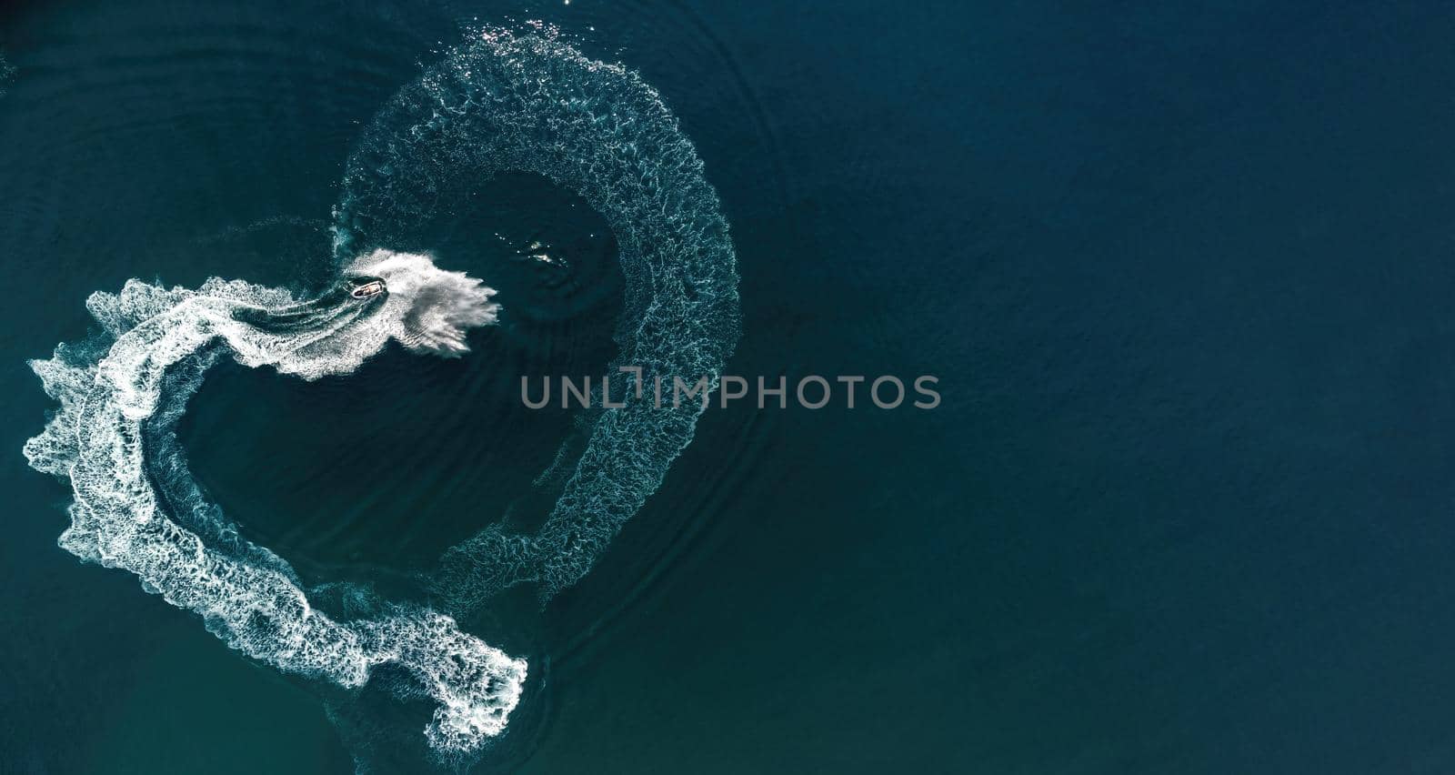 Aerial view heart-shaped trace on the water from a jet ski. Valentine day love symbol of heart shape, love, feelings