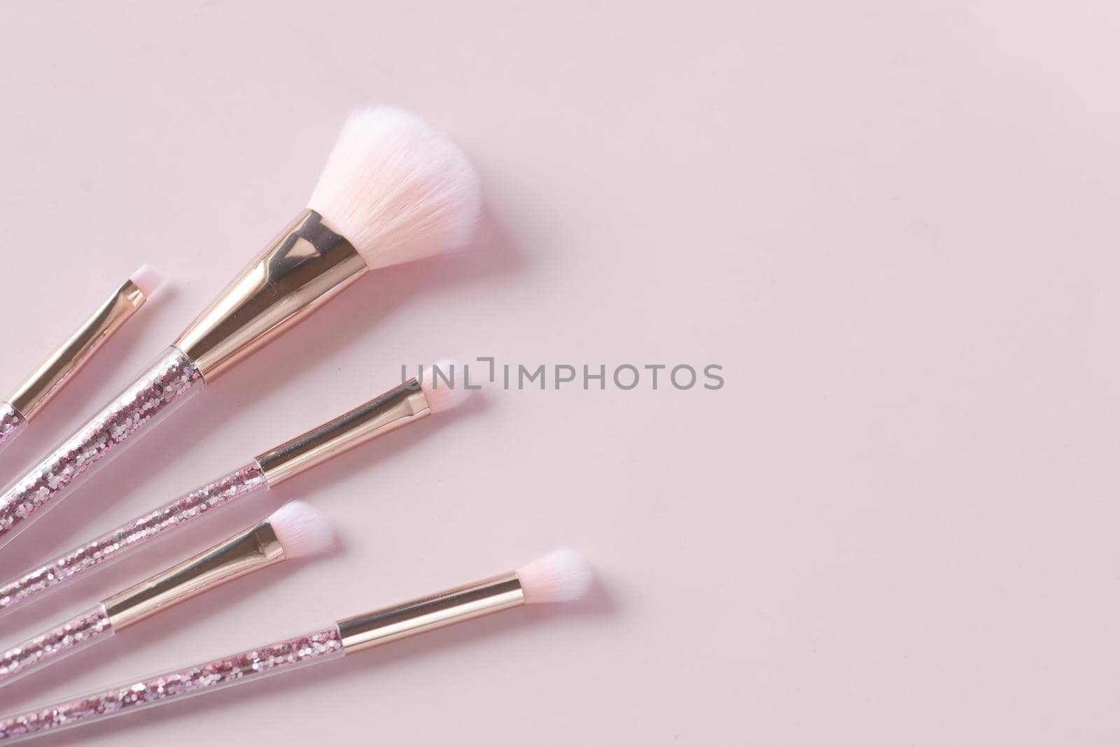 beauty brush on light pink background .