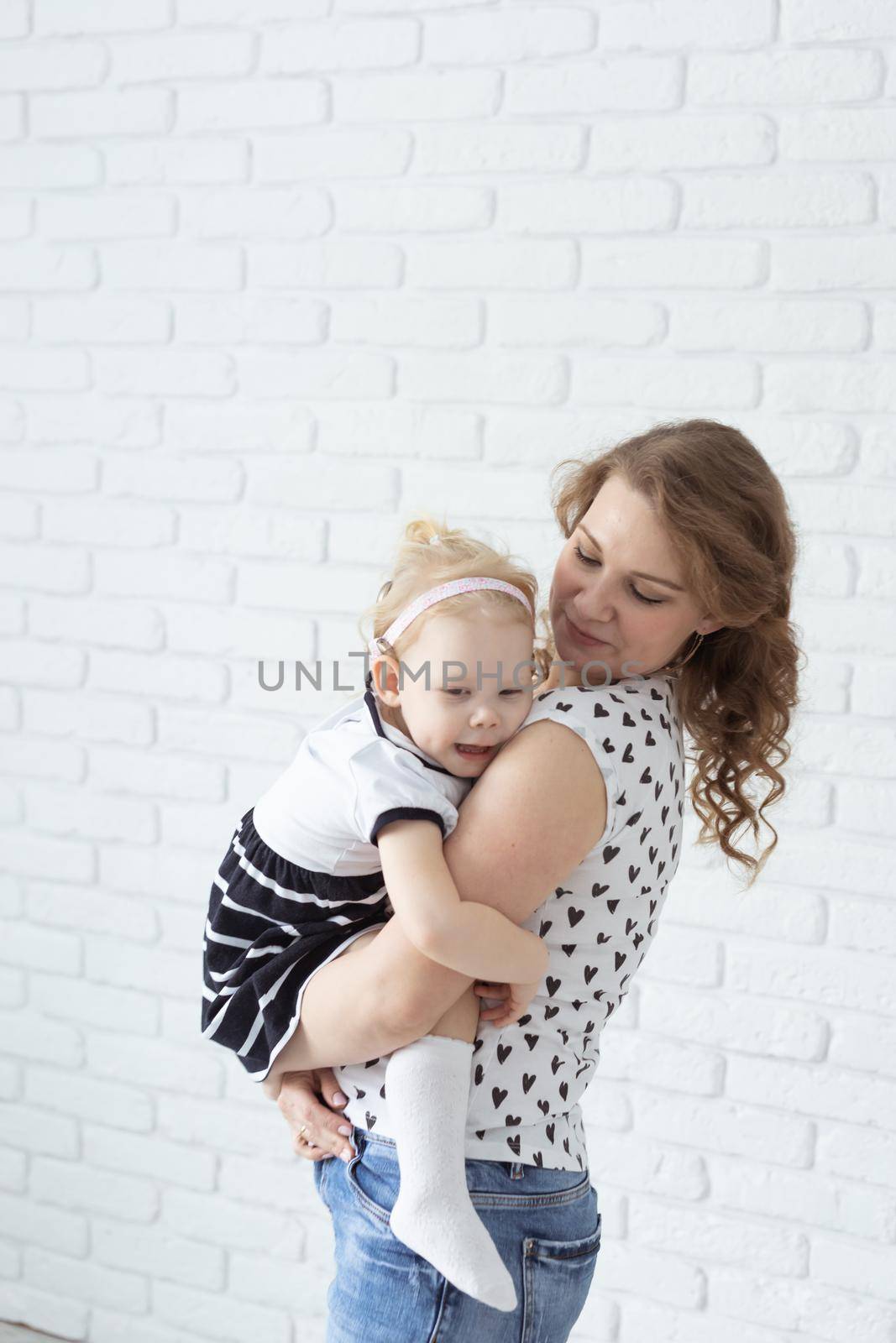 Baby with cochlear implant hearing aid having fun with her mother - deafness and diversity concept. Copy space place for advertising