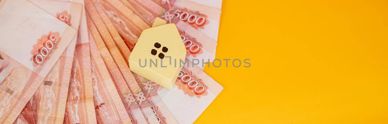 toy house on banknotes, buying your own home, mortgage, symbol of material well being