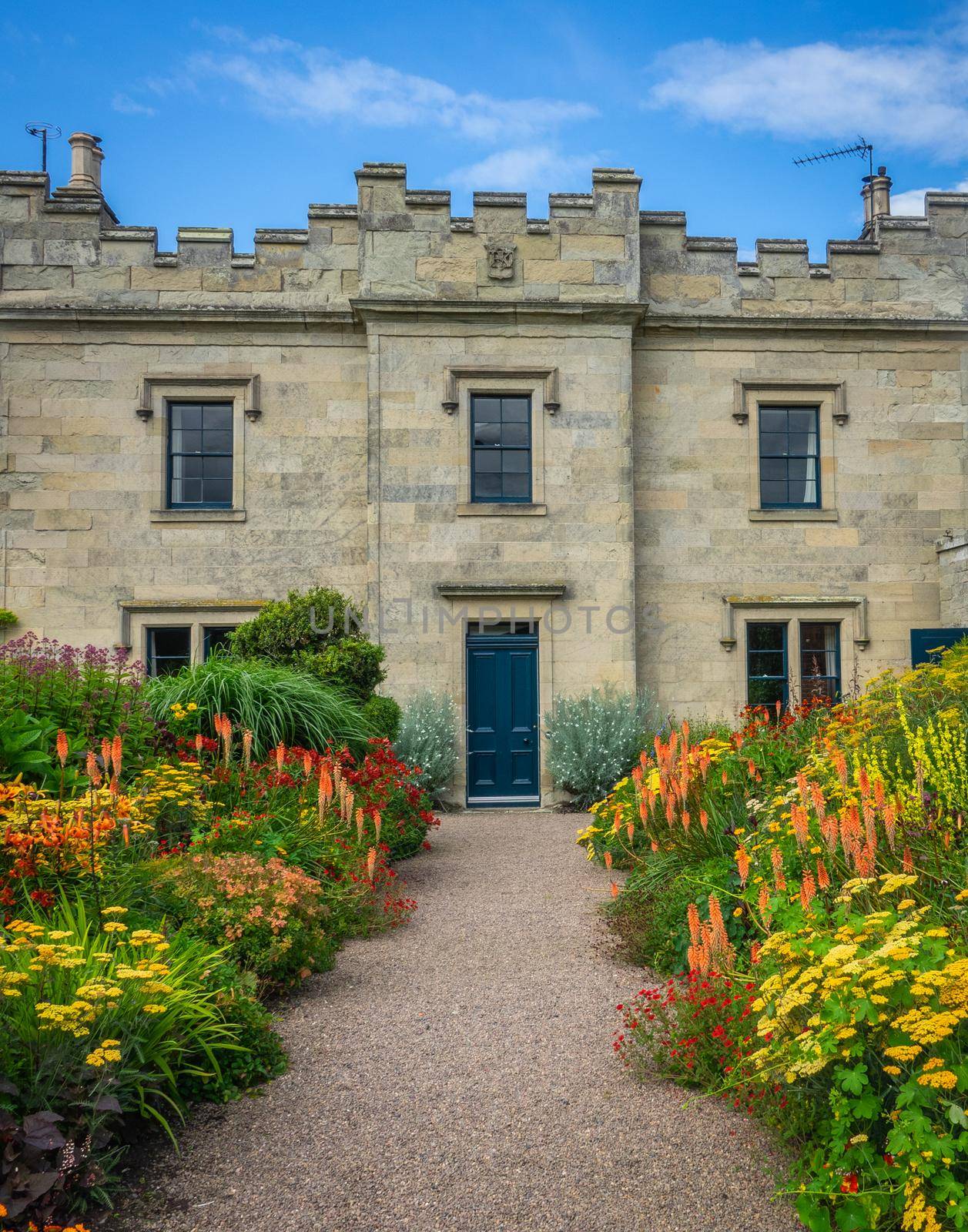 Beautiful Flowerbeds Lining The Approach To A Grand Old English Stately Home Or Mansion