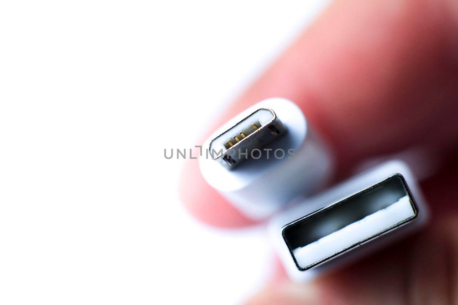 Hand holding micro USB cable connector on white background