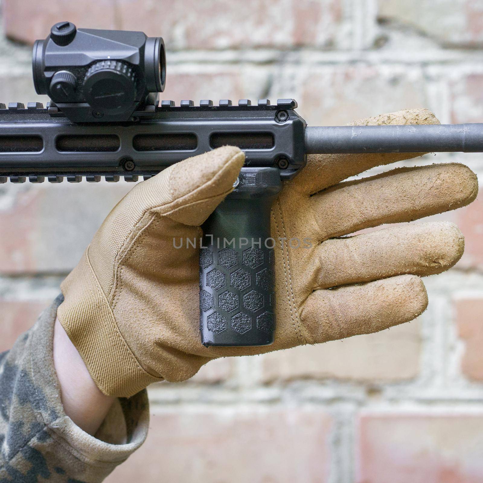 man hand in tactical glove hold front grip for a shot gun. Handgun im man hand ready to use. Shooter man ready to hit the target holding a hand grip.