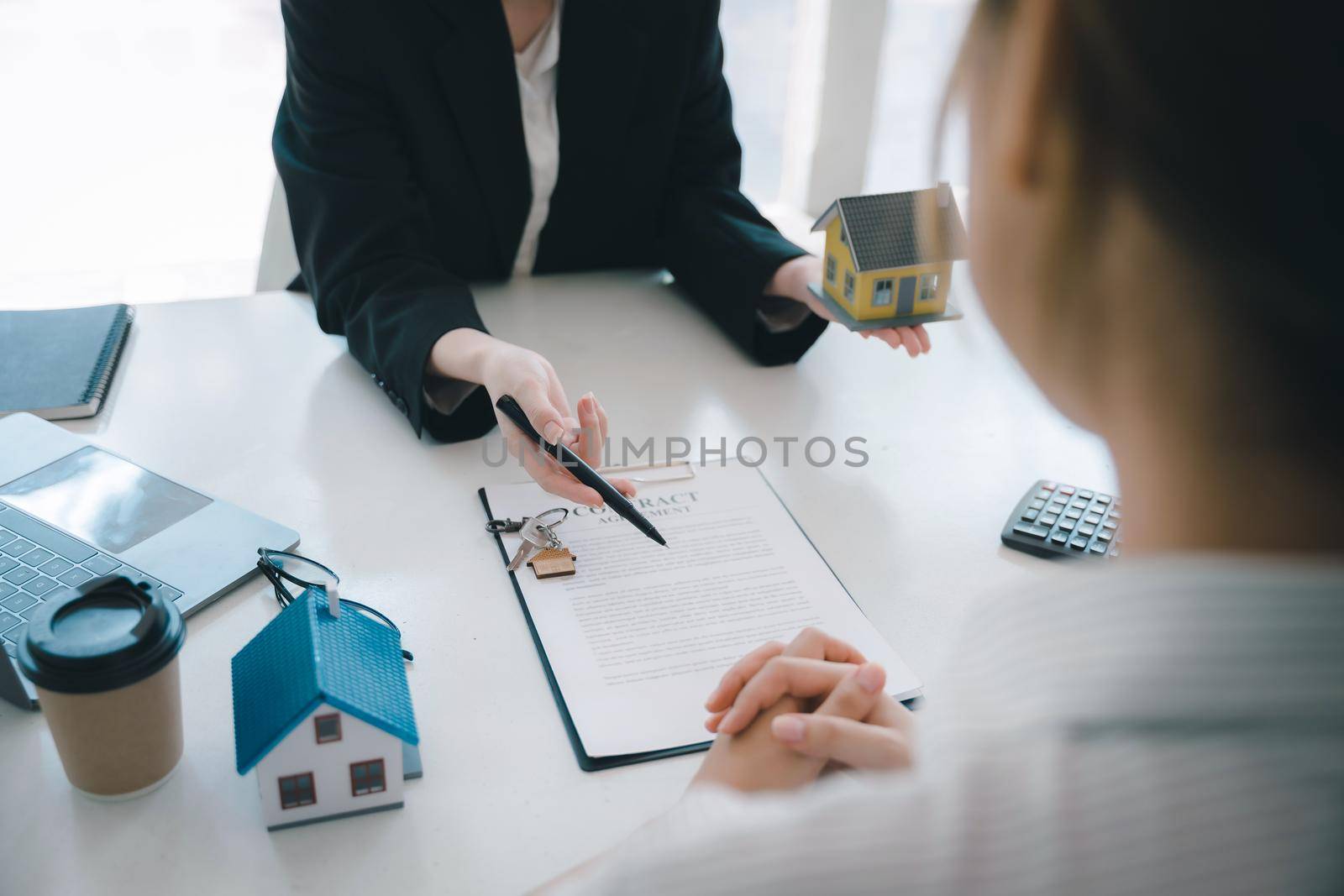 Guarantee, mortgage, agreement, contract, signed, real estate agent pointing to documents for customers to read the agreement before signing important documents by Manastrong