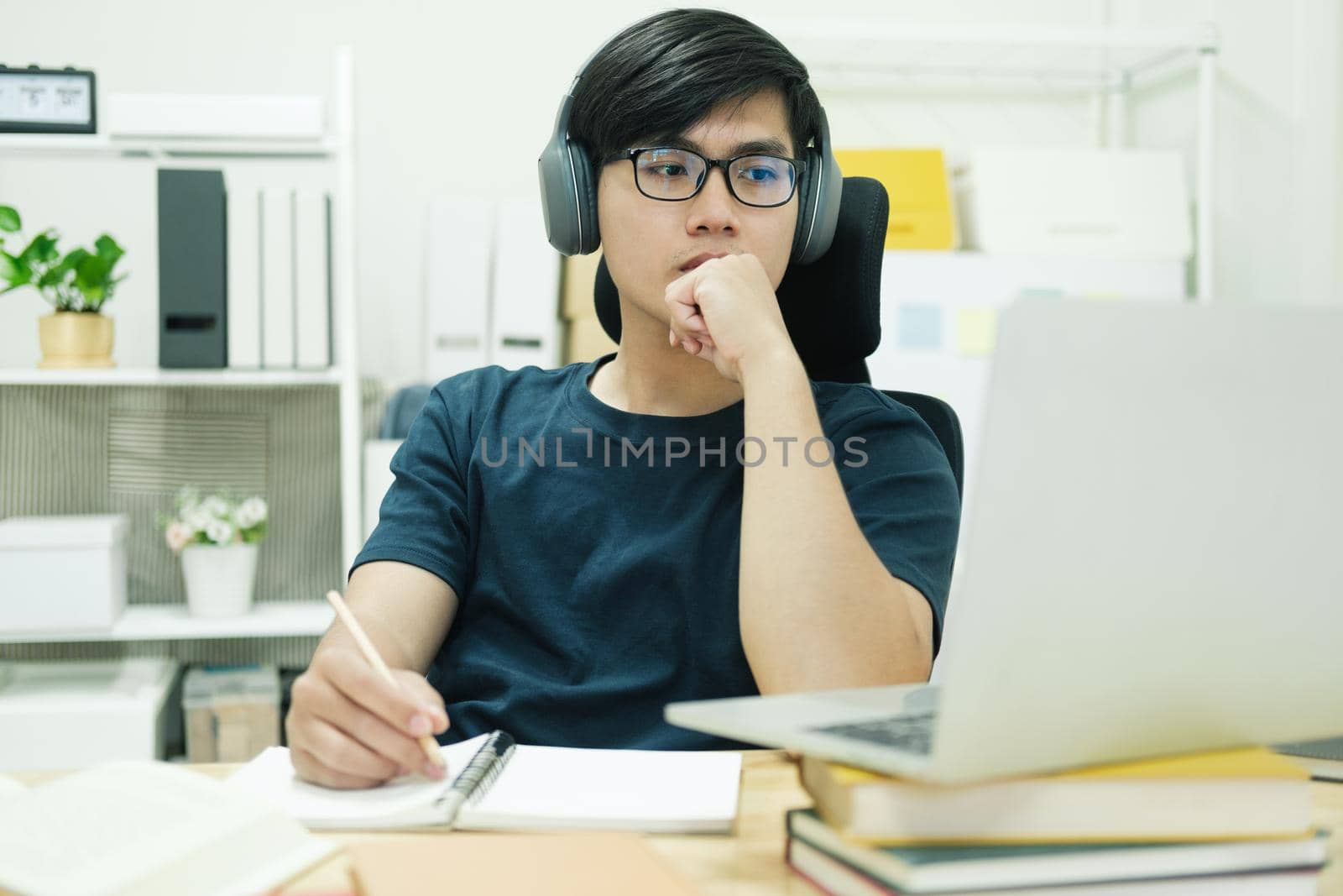 Young male student study at home. He using laptop and learning online.
