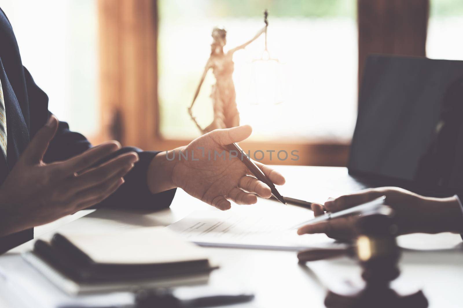 Business woman and lawyers discussing contract papers with brass scale on wooden desk in office. Law, legal services, advice, Justice concept. by itchaznong