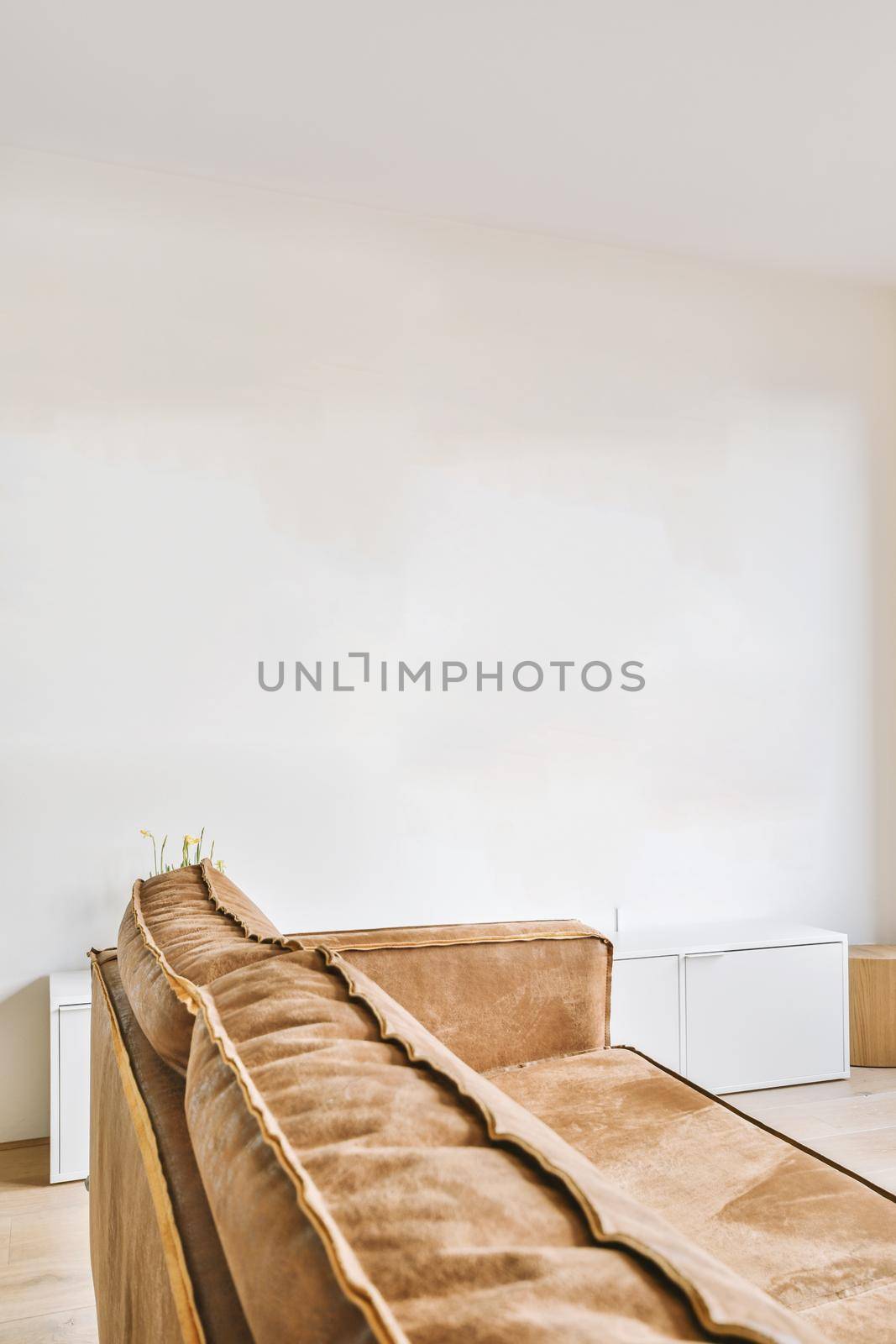 Bright brown colored sofa with pillows in a room with white walls