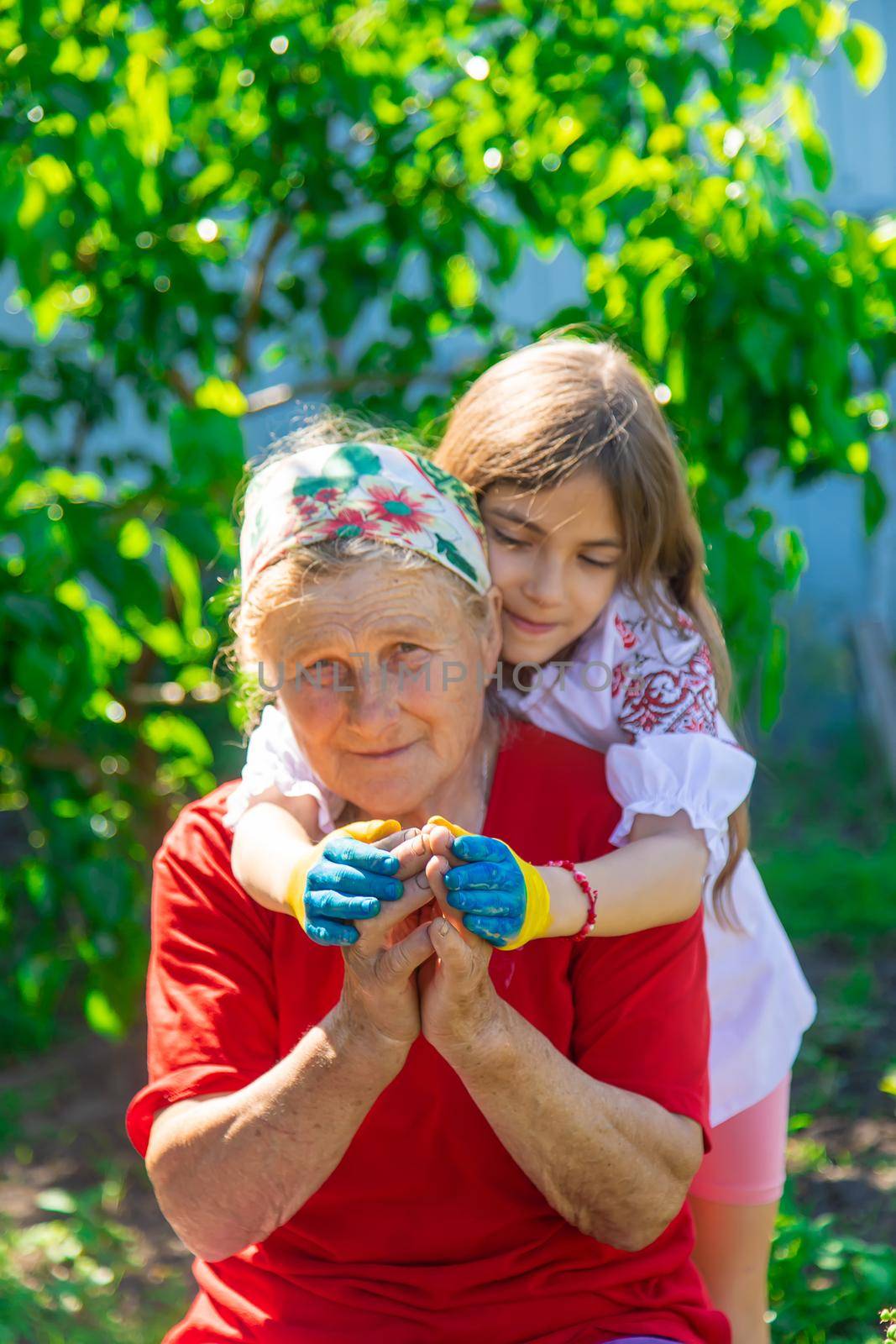 Child and grandmother hand drawn flag of Ukraine. Selective focus. Kid.