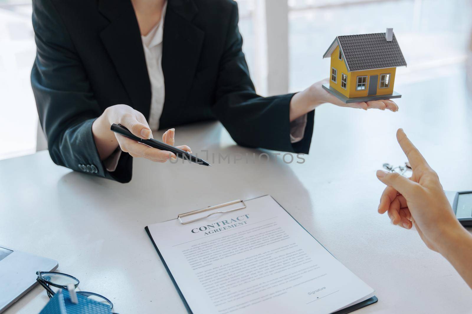 Guarantee, mortgage, agreement, contract, signed, real estate agent pointing to documents for customers to read the agreement before signing important documents.