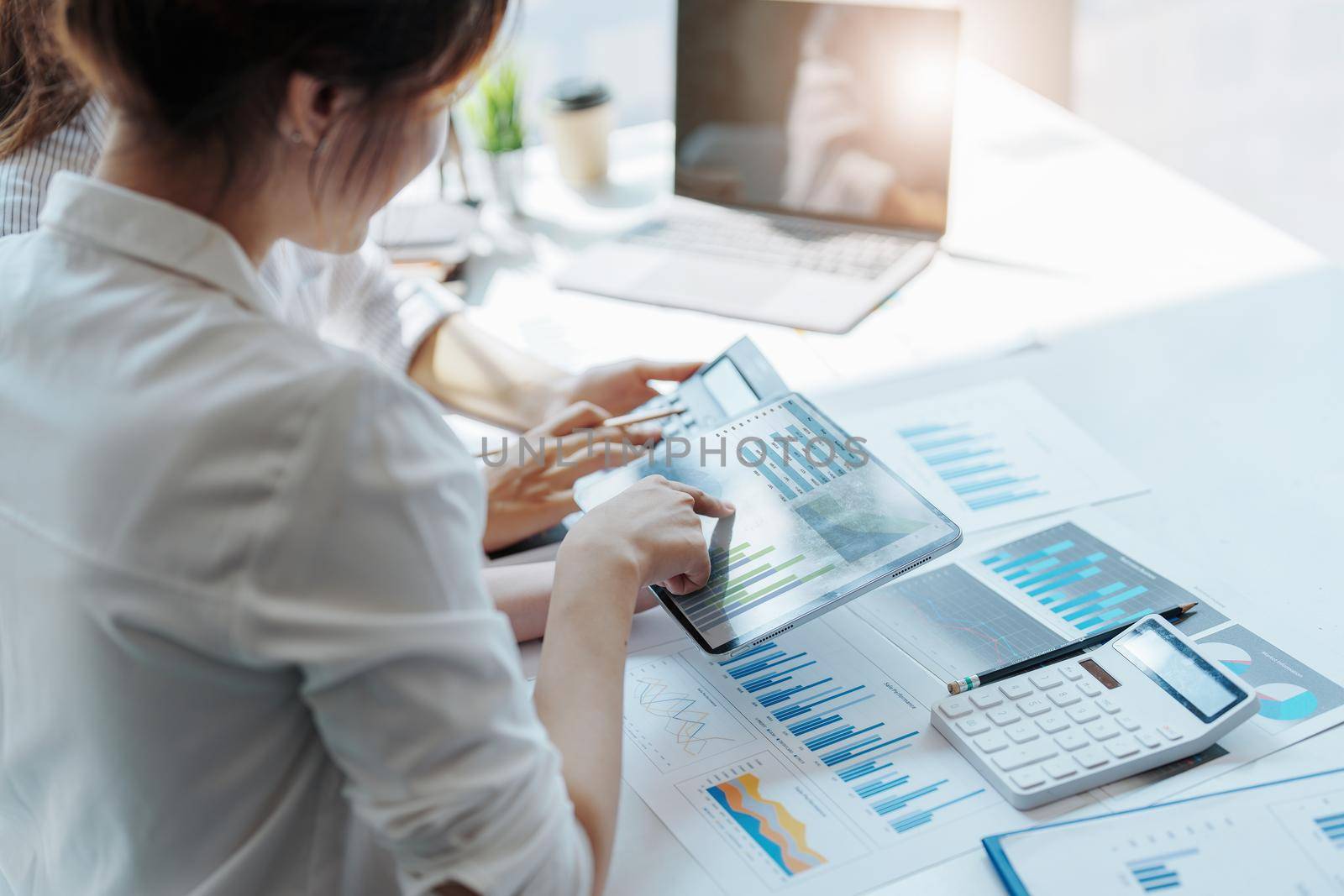 Negotiation, Analysis, Discussion, Portrait of an Asian women economist and marketer using tablet computer to plan investments and financial to prevent risks and losses for the company.