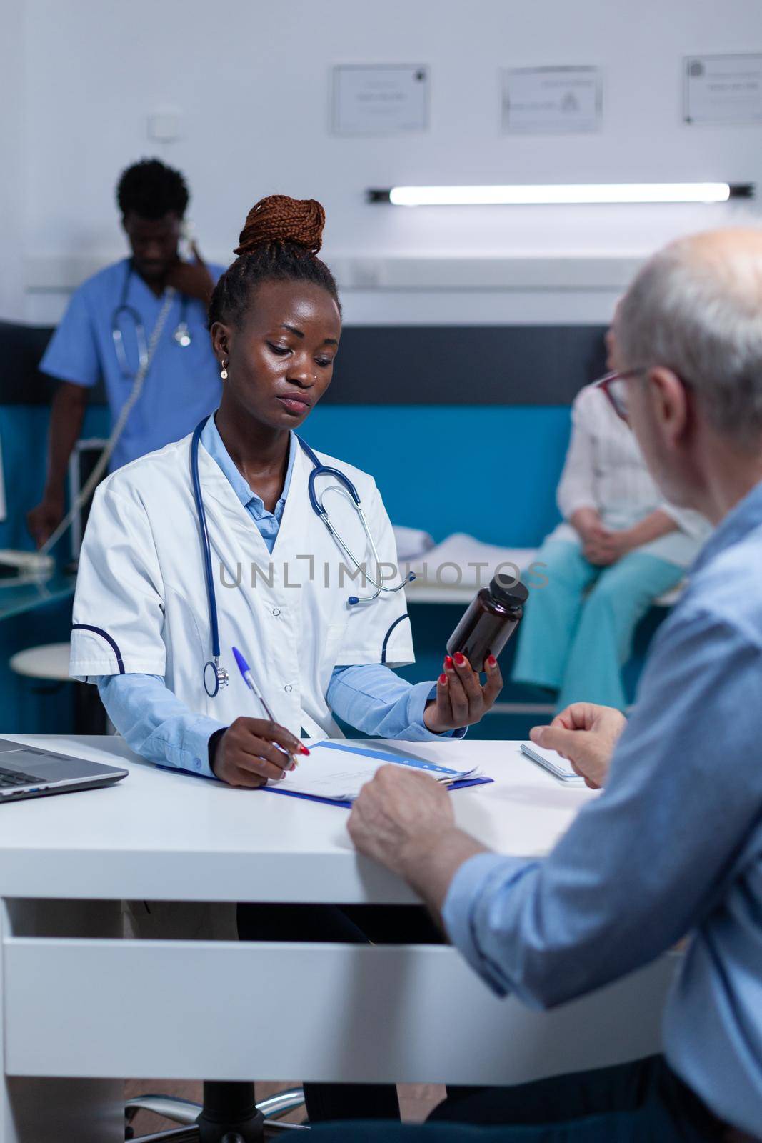 Healthcare hospital general practitioner specialist reviewing prescribed medication ingredients, side effects and benefits. Sick patient waiting for clinic medic to analyze antibiotic compounds.