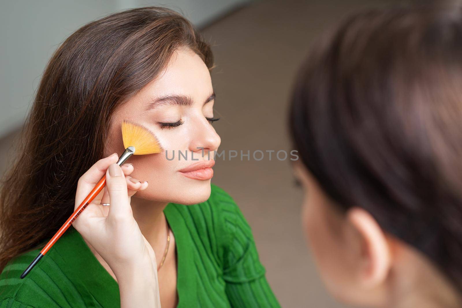 Make up artist applying professional make up of tonal foundation by okskukuruza