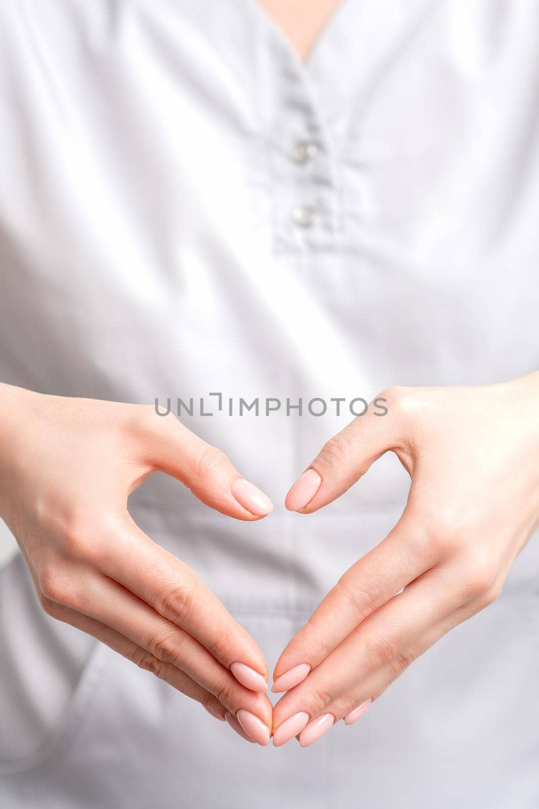 Female hands of doctor making heart shape by okskukuruza