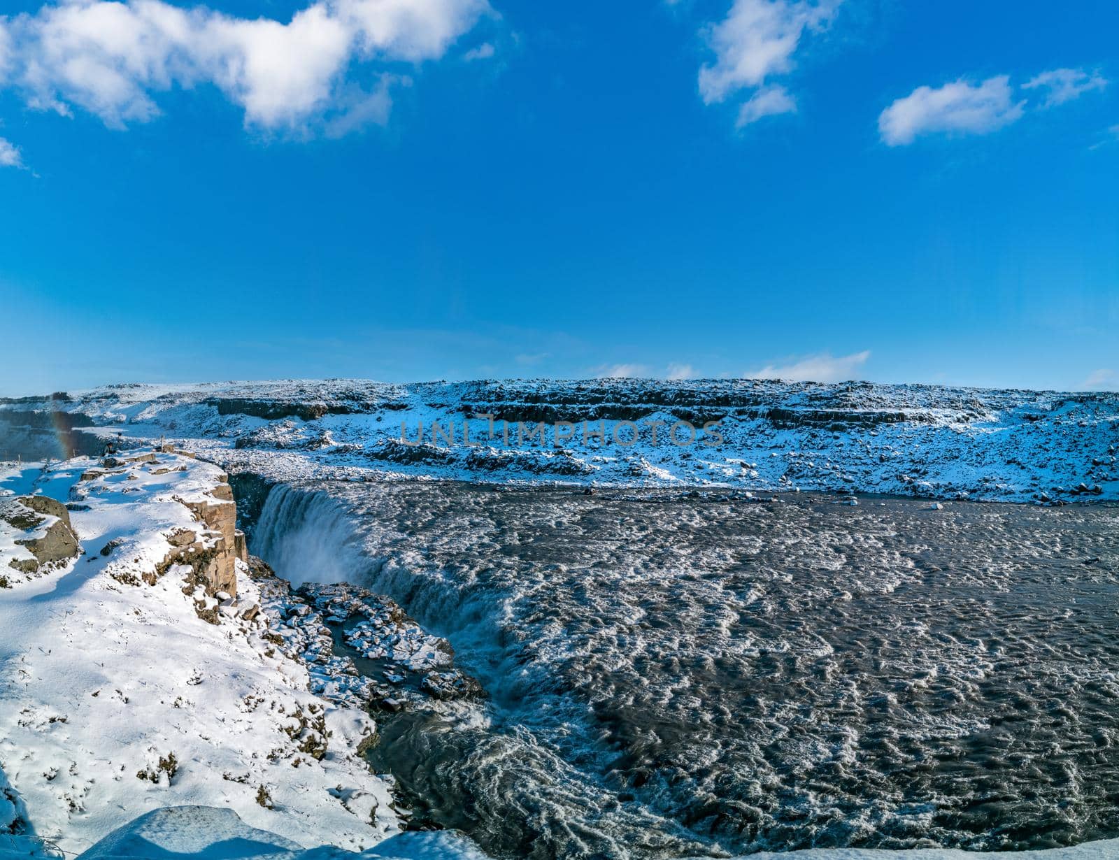 Dettifoss massive waterfall panoramic view and blue sky for text