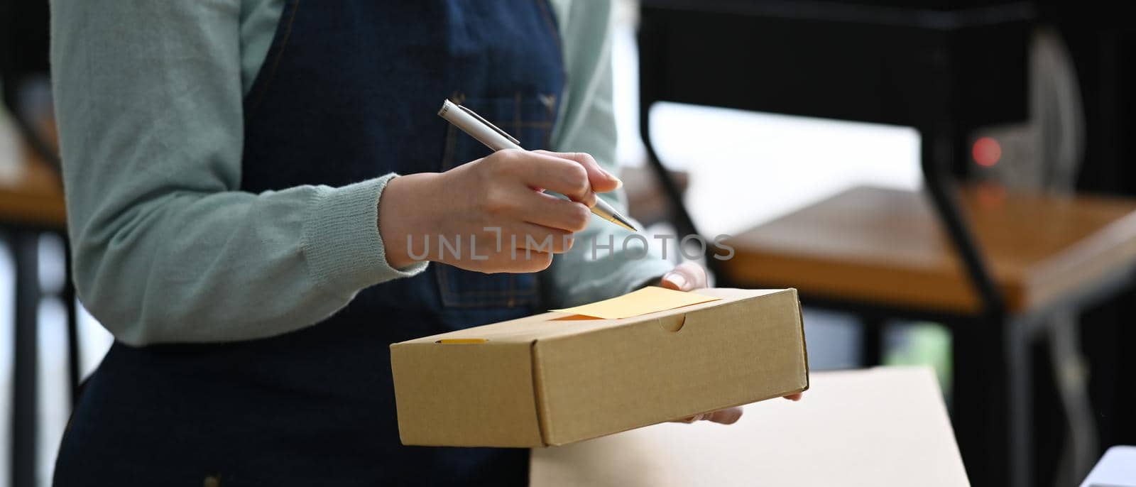 Young women business owner working at home office with packing box. E-commerce, online selling concept.