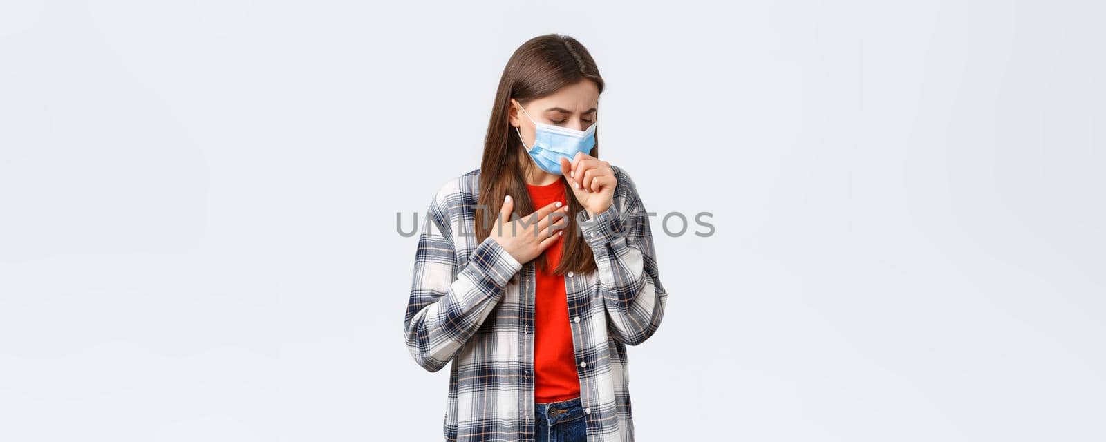 Coronavirus outbreak, leisure on quarantine, social distancing and emotions concept. Woman in medical mask coughing, feeling sick, touching lungs, have covid-19 symptoms, being ill.